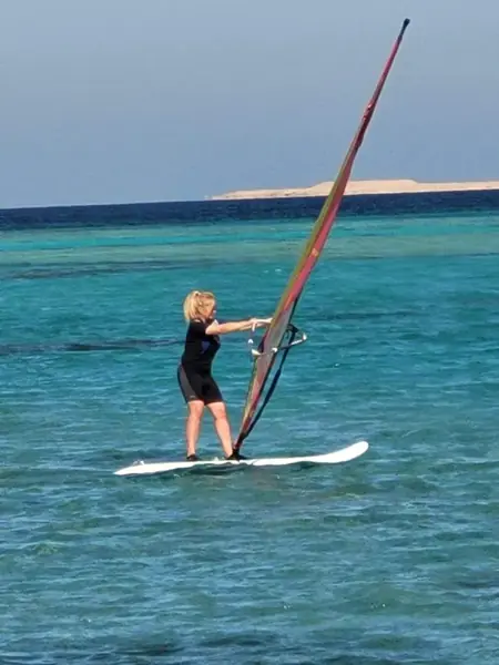 Guest windsurfing on turquoise water