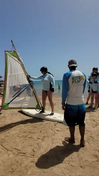 Instructor teaching windsurfing on the beach