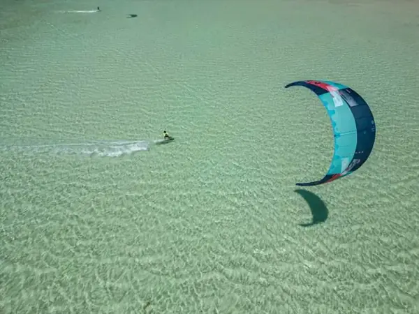 Aerial view of a kiteboarder in clear shallow water