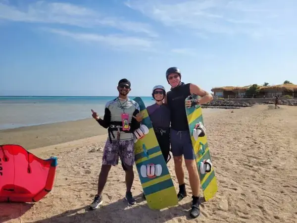 Instructor with guests holding their kiteboards