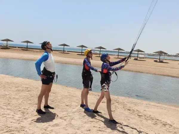 Guests learning to fly a kite on the beach