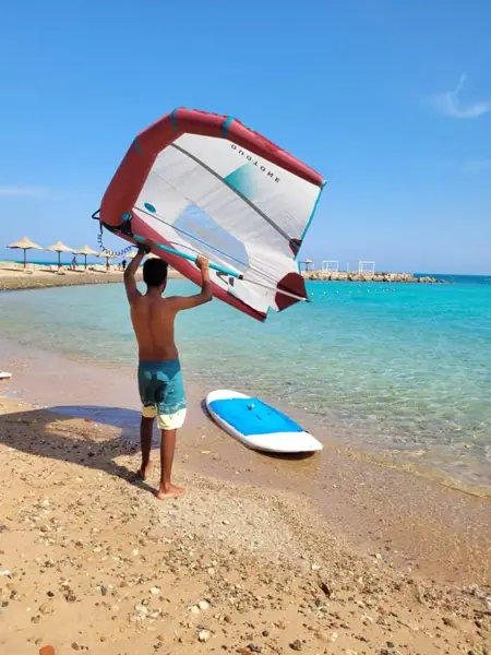 Instructor carrying a wing to the water